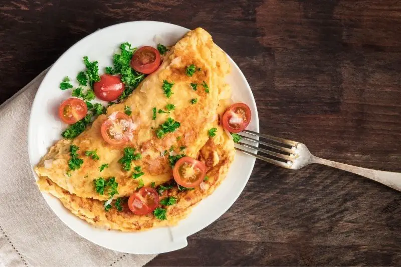 omelette with cherry tomatoes, parsley and grated cheese