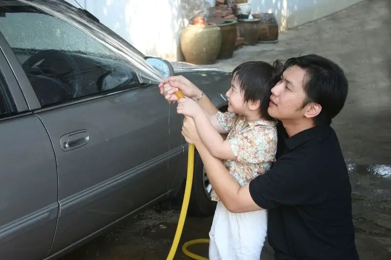 man and kid washing car