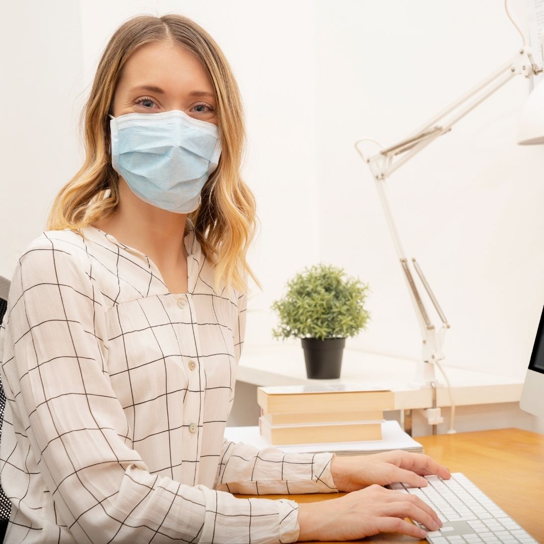 businesswoman working from home wearing protective mask