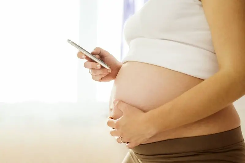pregnant woman checking phone