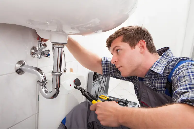 A plumber fixing a bathroom sink