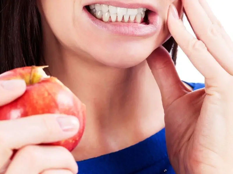woman with tooth pain after biting an apple