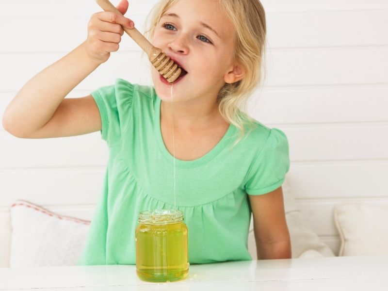 little girl eating honey
